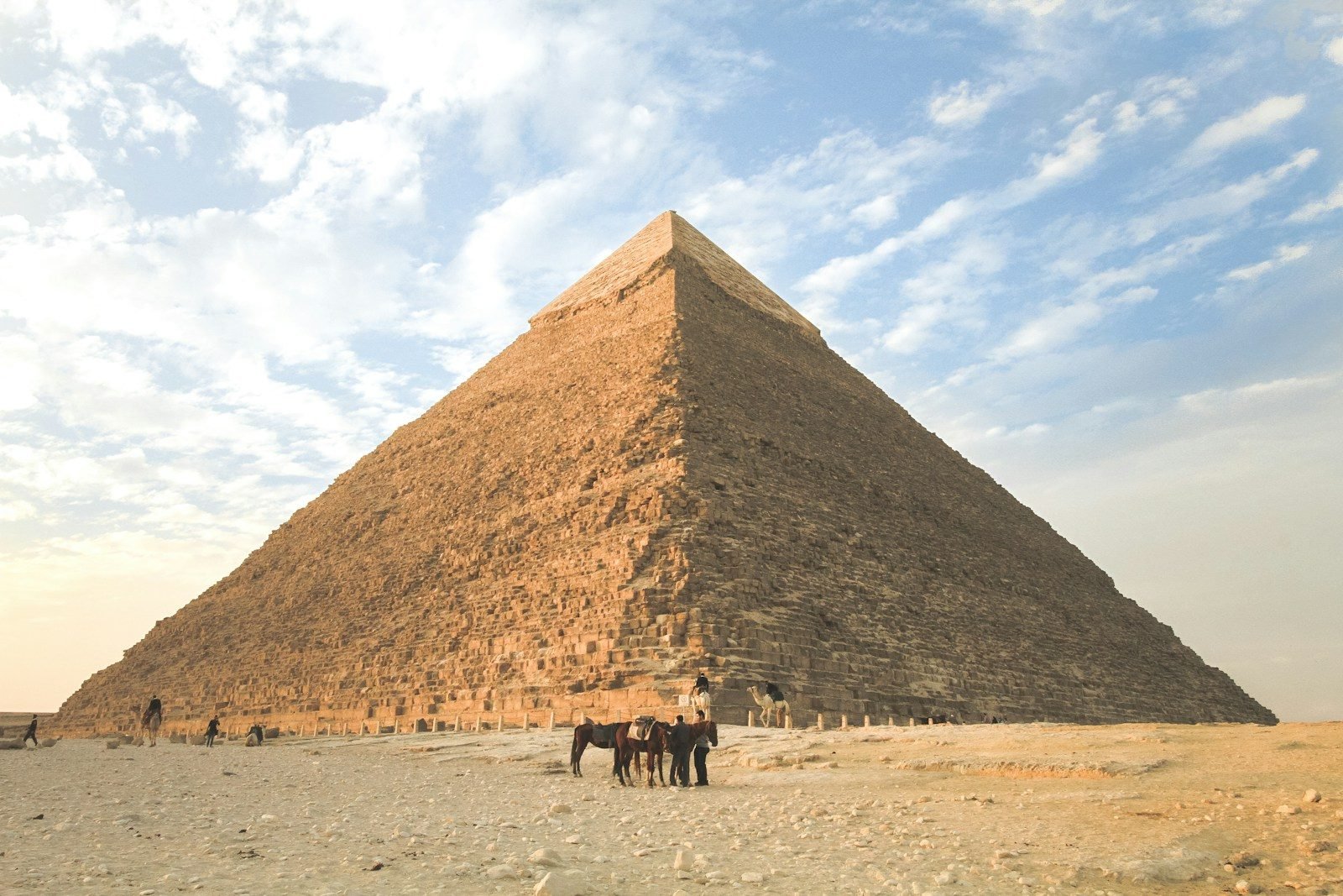 La pirámide de Kefrén en la meseta de Giza, con unos pocos camellos sobre la arena a sus pies.