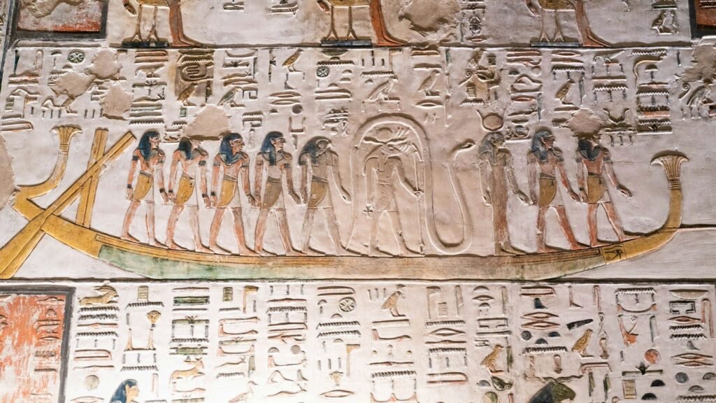 Relieve pintado de la barca solar con dioses y jeroglíficos en la pared de una tumba del antiguo Egipto