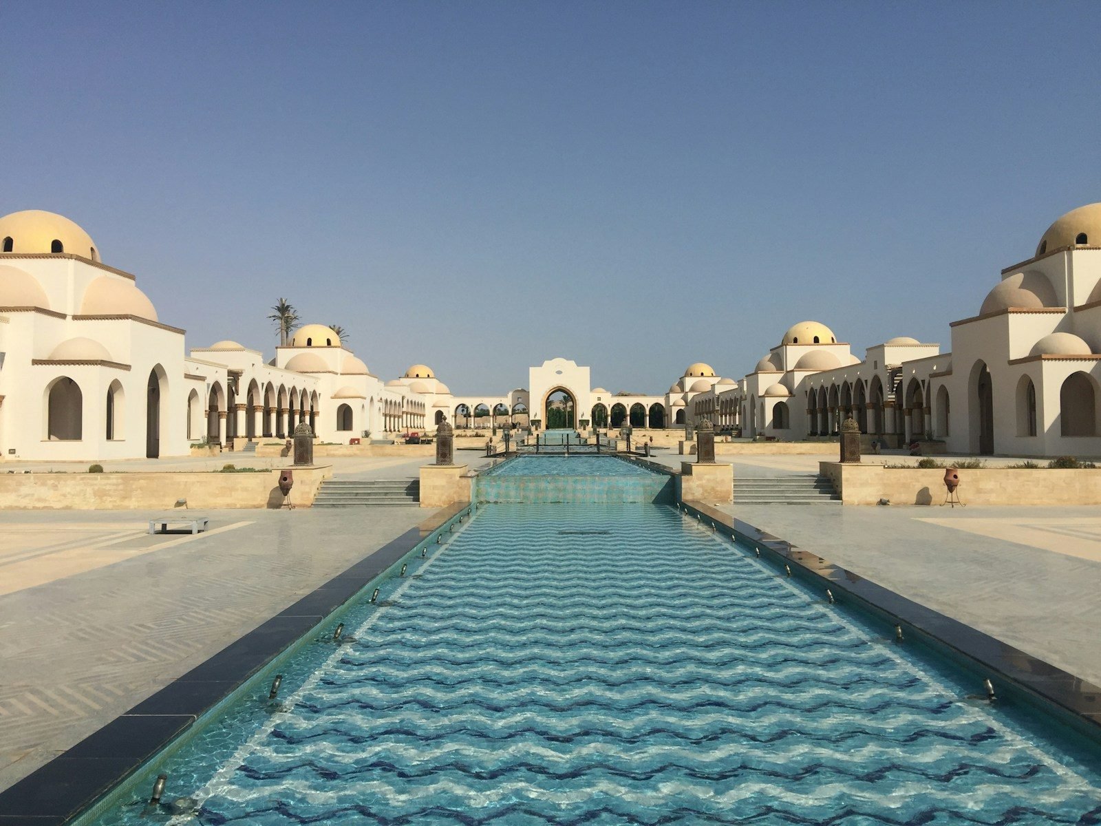 The Old Town piazza at Sahl Hasheesh, white domed arcades along a wave-tiled water channel