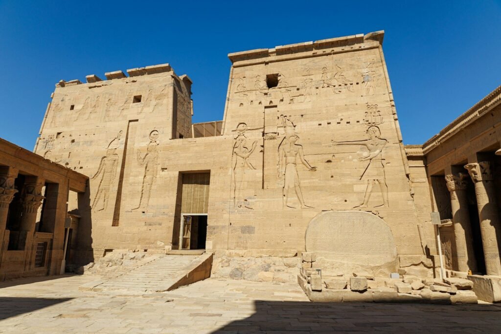El primer pilono del templo de Filae, en Asuán, con los relieves de los dioses bajo un cielo azul