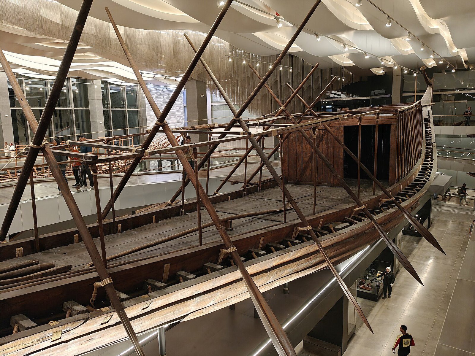 La barca solar de Keops, de madera, en el Museo de las Barcas de Keops del Gran Museo Egipcio, con largos remos sobre la cubierta