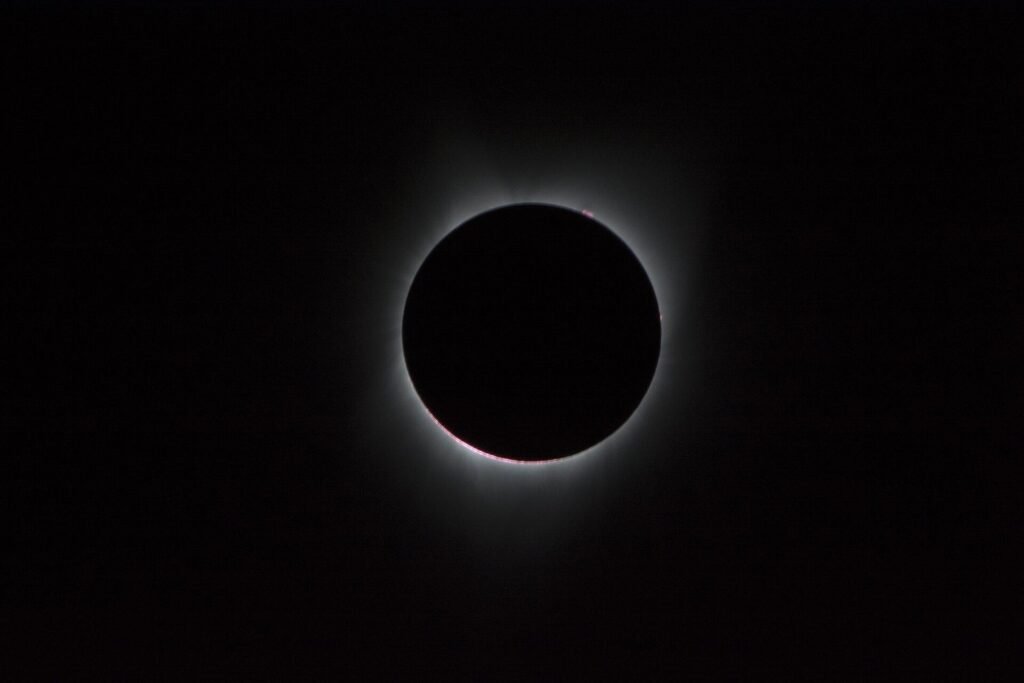 La corona solar rodea la Luna durante un eclipse solar total, con el cielo oscuro, en una fotografía de la NASA de 2017