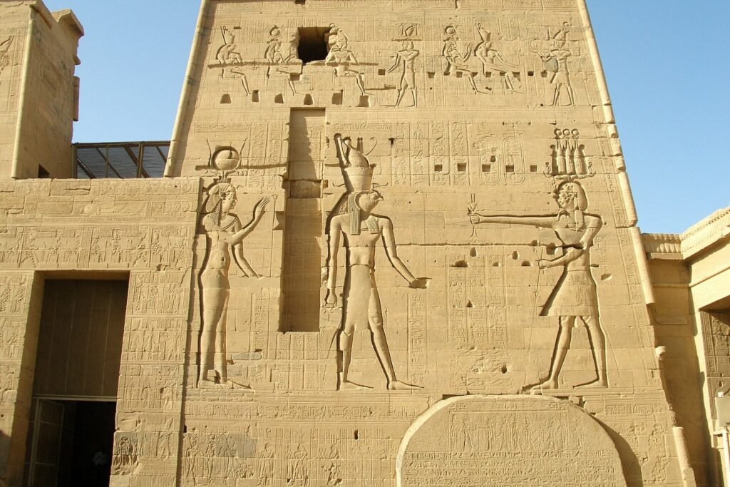 Pilono del templo de Isis en Filae con relieves de una diosa con cuernos y disco solar, Horus con cabeza de halcón y un rey ante los dioses